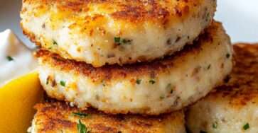 Croquettes de thon dorées et croustillantes, façonnées en petits disques, servies avec du citron et des herbes fraîches sur une assiette claire.