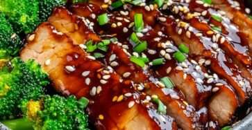 Tranches de porc laquées à la sauce teriyaki, parsemées de graines de sésame et servies avec du brocoli croquant dans une assiette moderne.