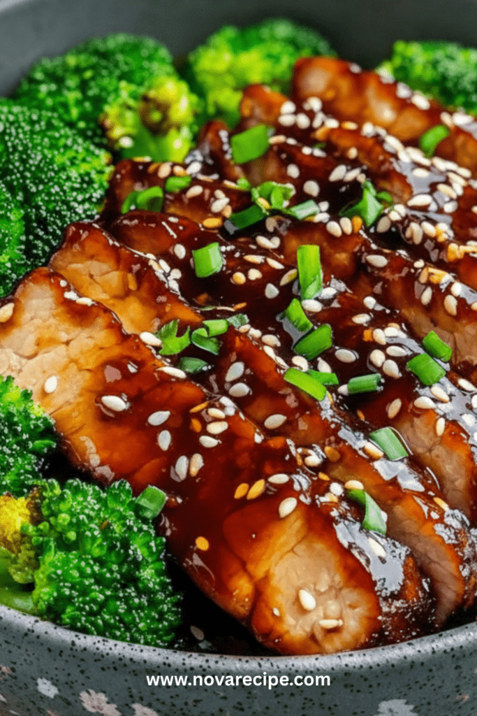 Tranches de porc laquées à la sauce teriyaki, parsemées de graines de sésame et servies avec du brocoli croquant dans une assiette moderne.